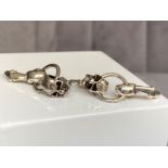 A pair of silver skull earrings, weighing in at 6.85grams