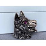 A silver dog brooch with red stone eyes, weighing in at 11.54grams