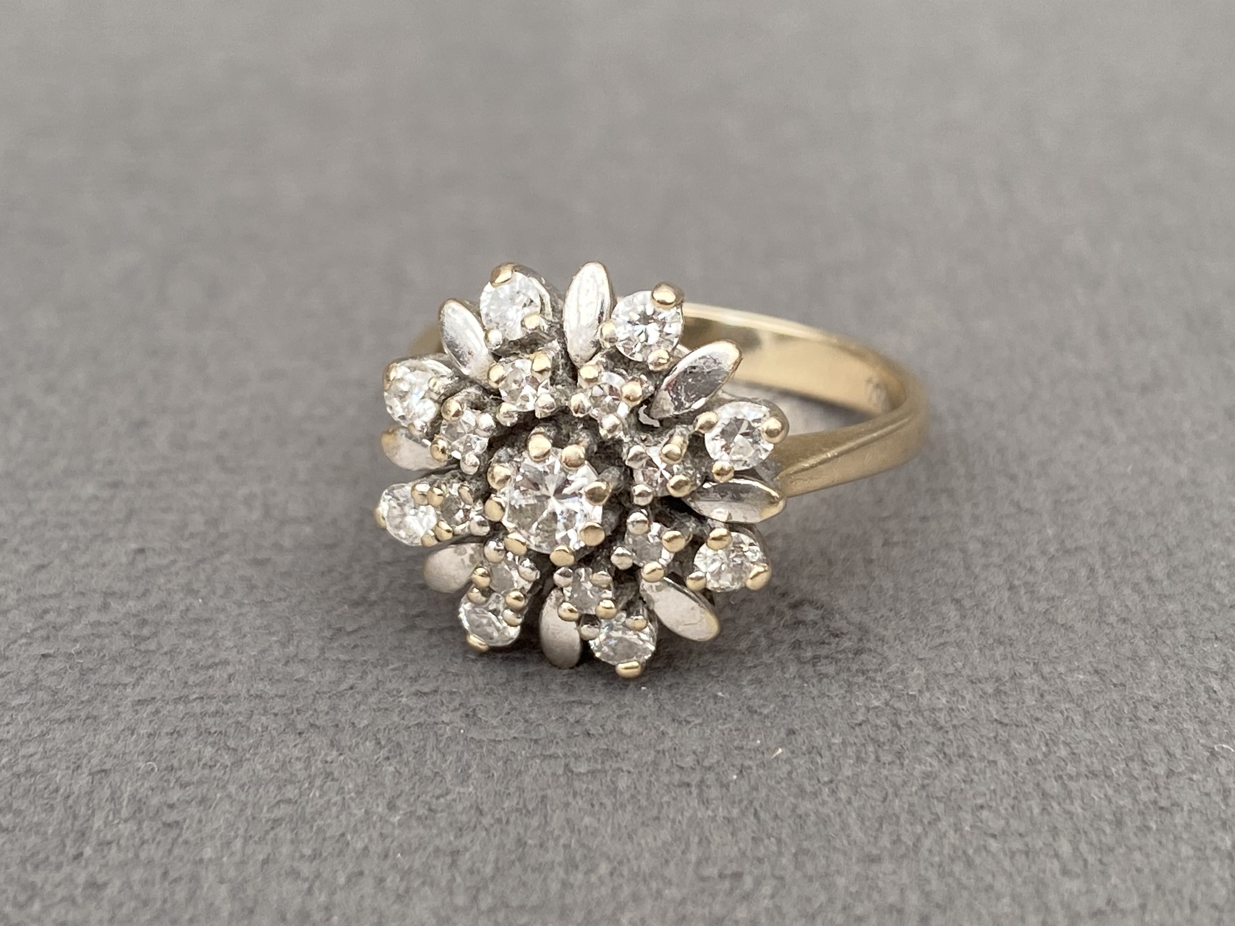 18ct gold diamond cluster ring featuring a .10ct centre stone weighing 4.88 grams Size I