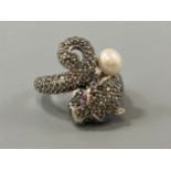 A silver marcasite panther ring set with a pearl drop and ruby eyes, weight 8.76 grams