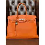 Hermes Birkin 35 from the 2012 collection in orange togo leather with palladium hardware. Box and