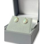 Pair of oval cut opal earrings set in silver mount weighing 0.91 grams