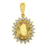 A yellow sapphire and brilliant-cut diamond cluster pendant.