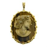 A 9ct gold cameo pendant, depicting a woman in profile, with tiger's-eye panel and single-cut