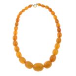 A graduated orange bead necklace.