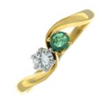 An 18ct gold brilliant-cut diamond and emerald two-stone crossover ring.