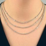 A brilliant-cut diamond graduated three-row necklace, with similarly-cut diamond spacer highlights