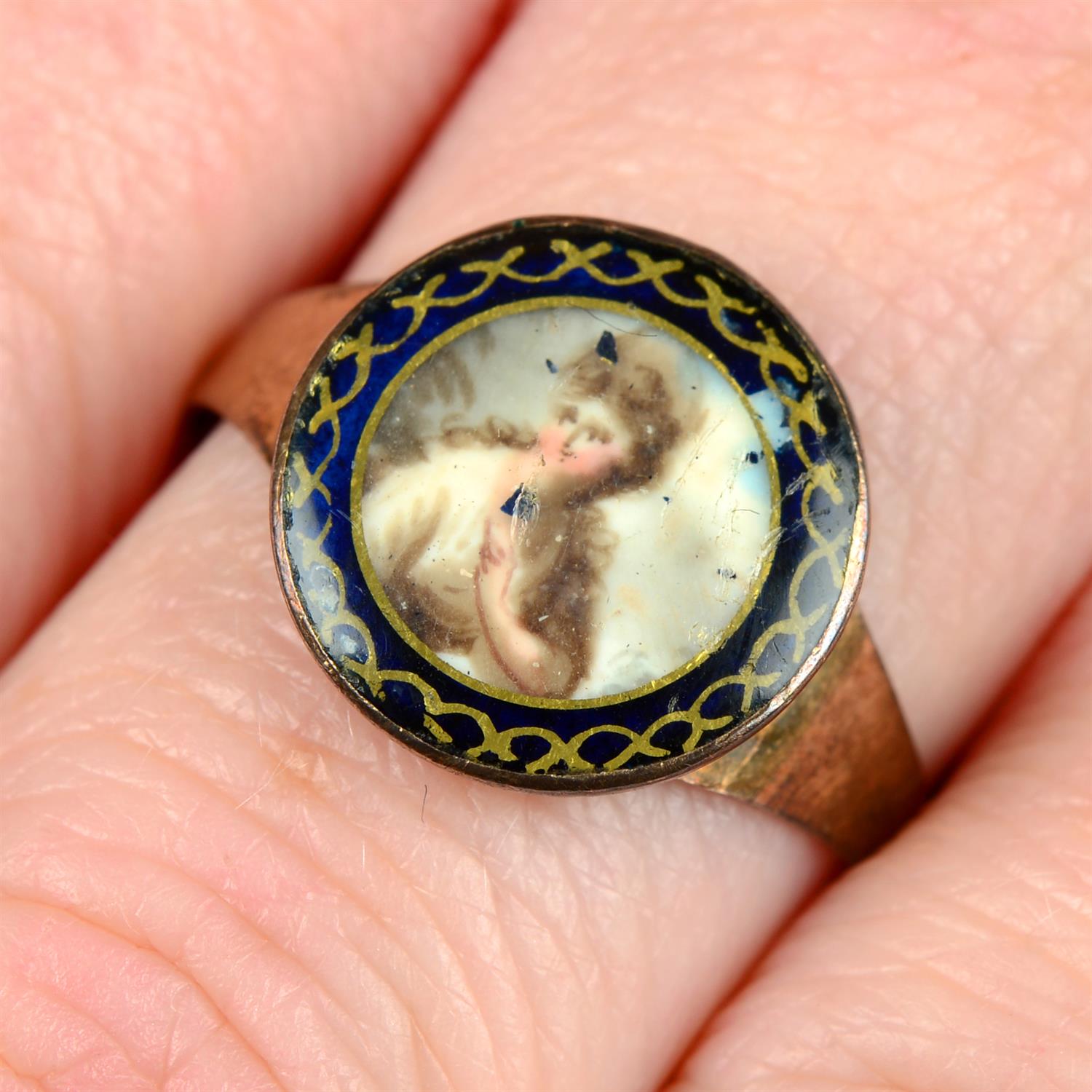 An early to mid 19th century gold portrait miniature ring, with blue and gilt painted surround.
