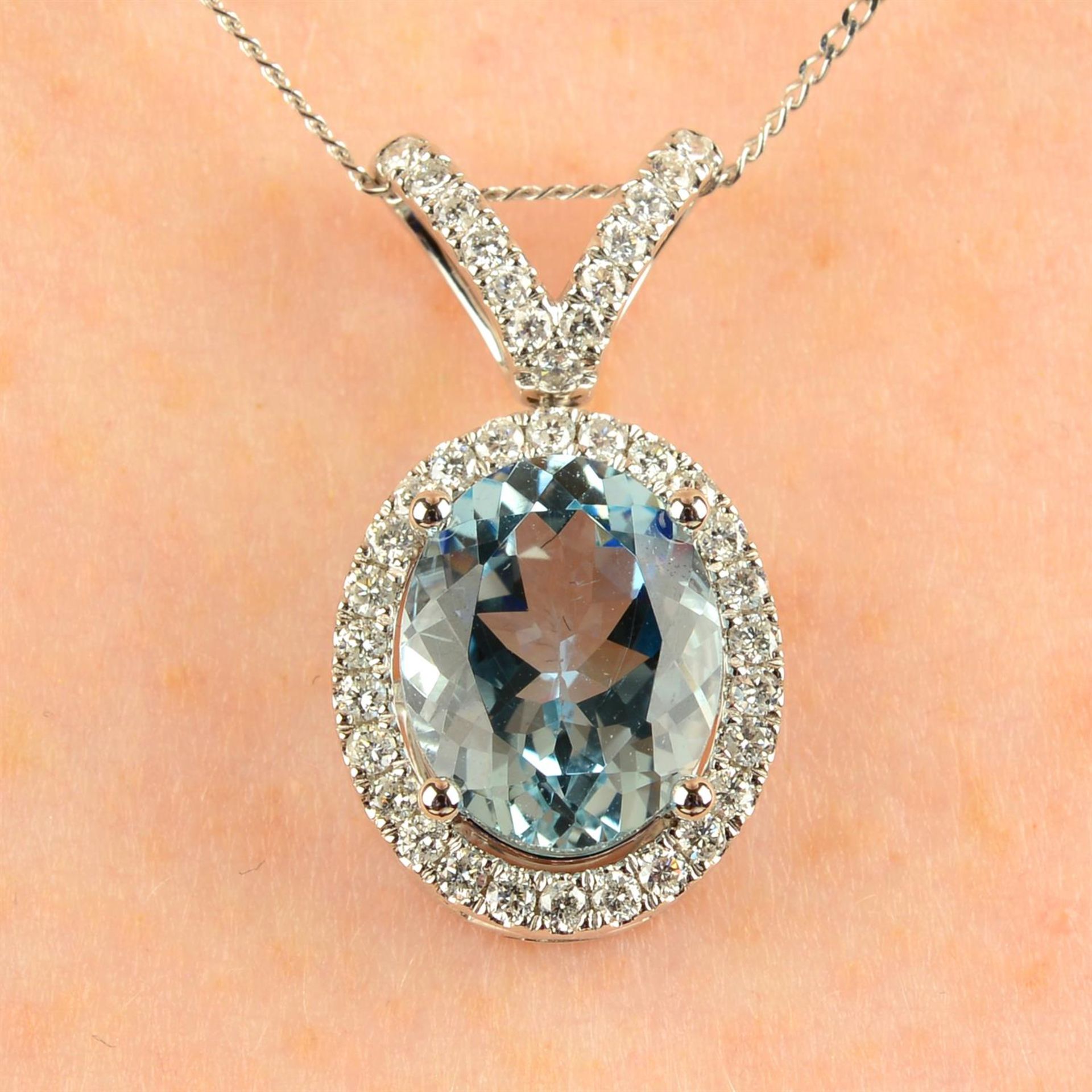An 18ct gold aquamarine and brilliant-cut diamond pendant, with trace-link chain.