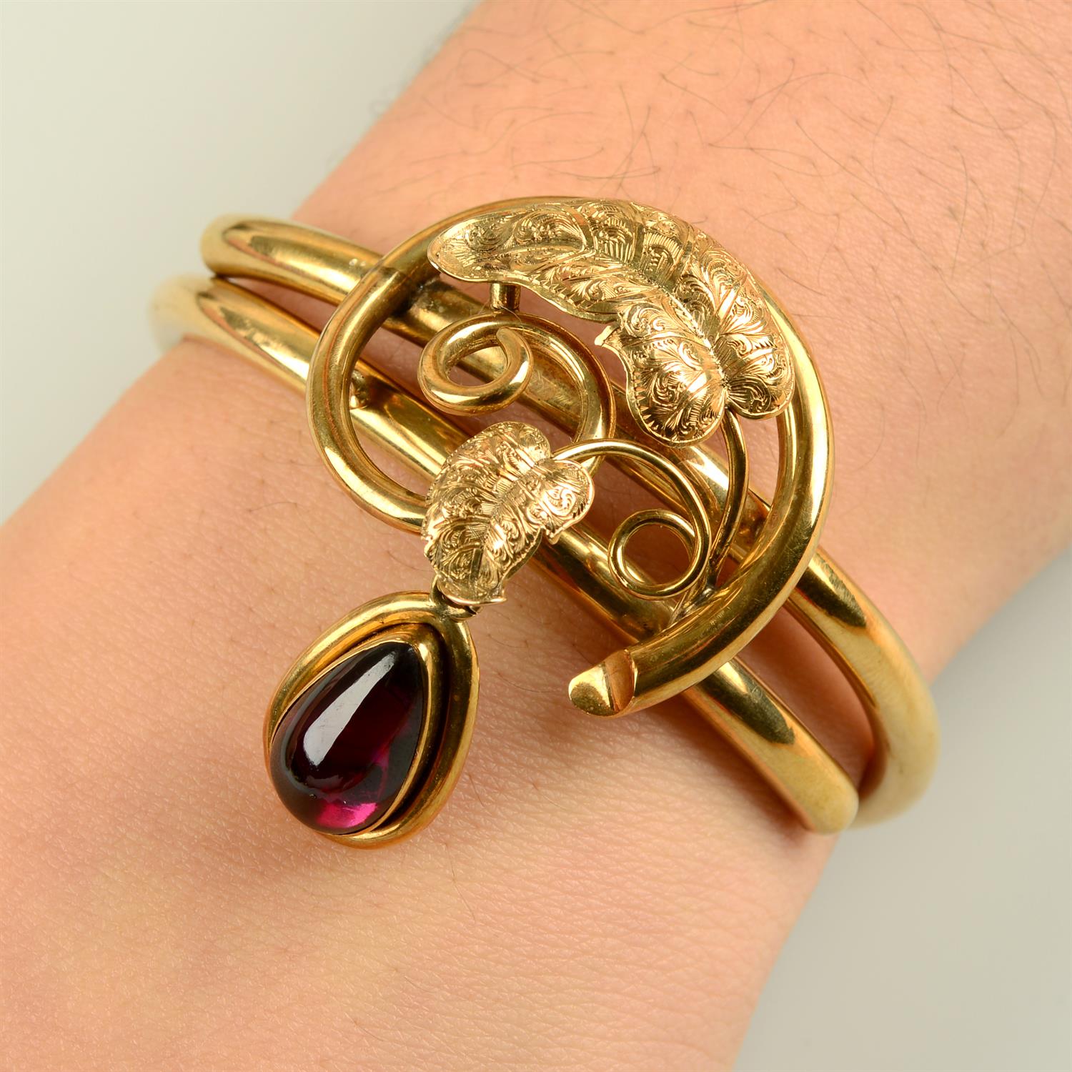 A mid to late Victorian 14ct gold foliate hinged bangle, with garnet locket drop.