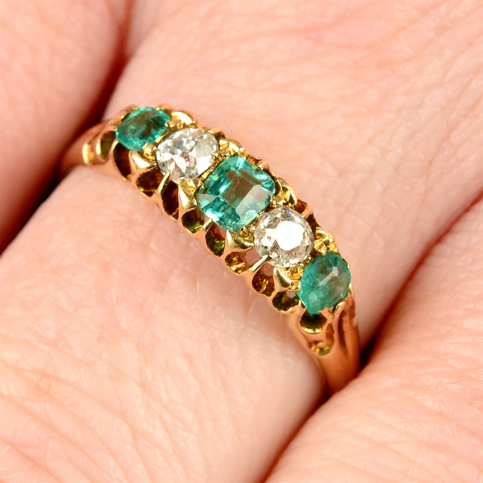 An 18ct gold emerald and old-cut diamond five-stone ring, with partial band replacement.