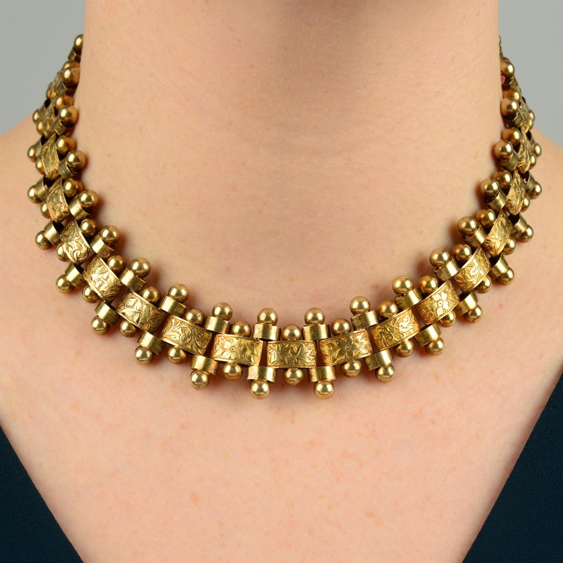 A late Victorian gold floral engraved and bead motif collar necklace.