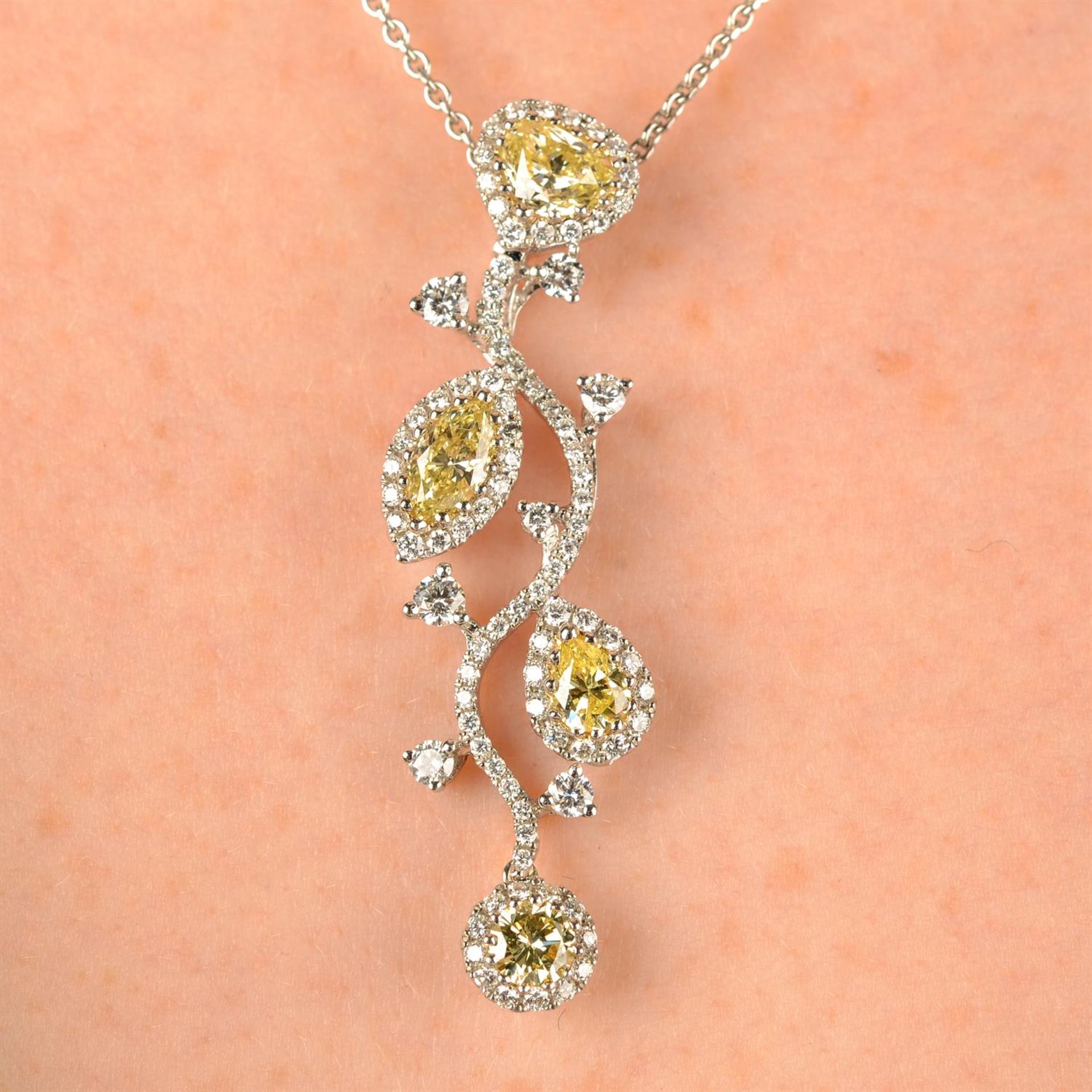 An 18ct gold brilliant-cut diamond and vari-shape 'yellow' diamond stylised floral pendant,
