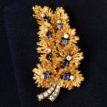 A mid 20th century gold brilliant-cut diamond and sapphire textured brooch.