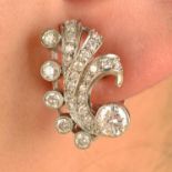 A pair of 1940s brilliant-cut diamond scroll earrings.