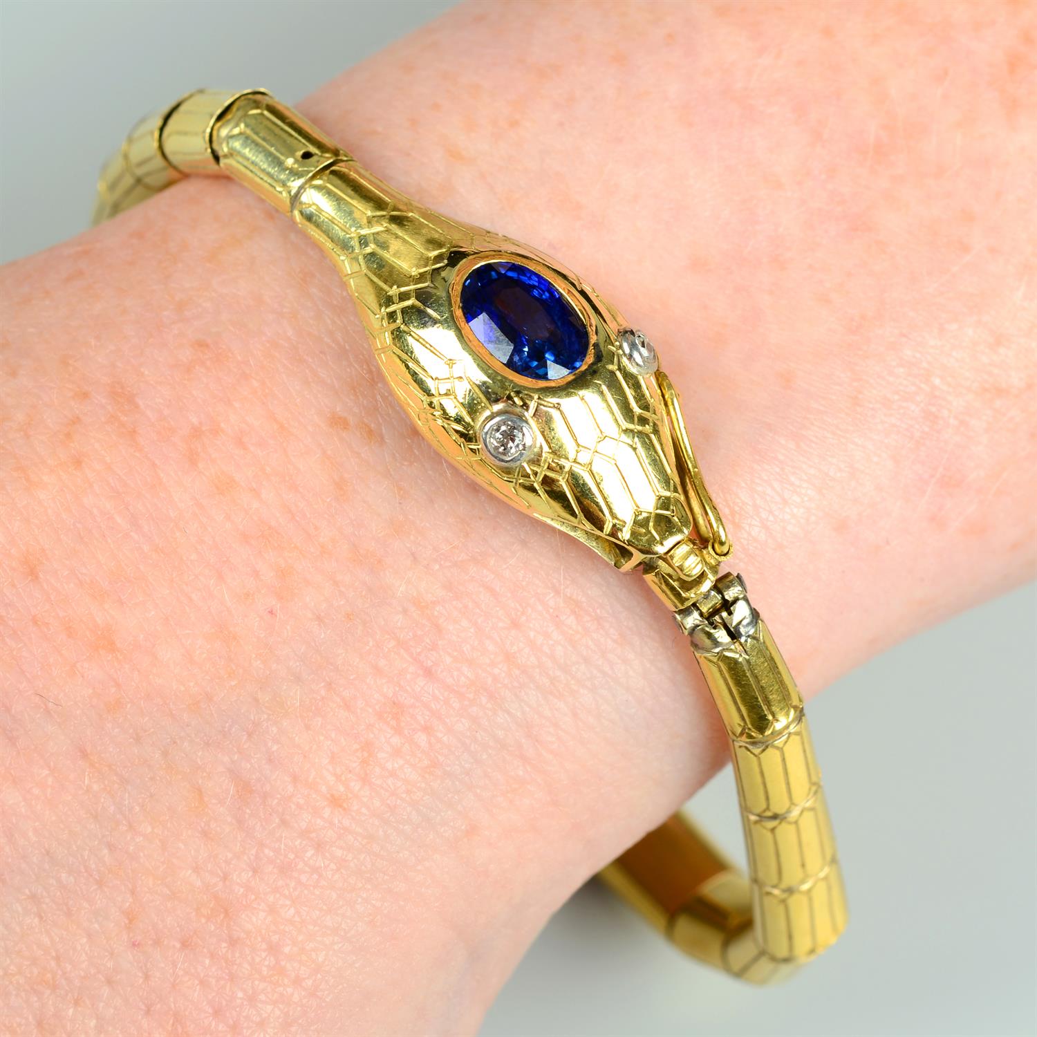 A 19th century gold snake bracelet, with sapphire crest and old-cut diamond eyes.