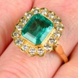 An emerald and brilliant-cut diamond cluster ring.