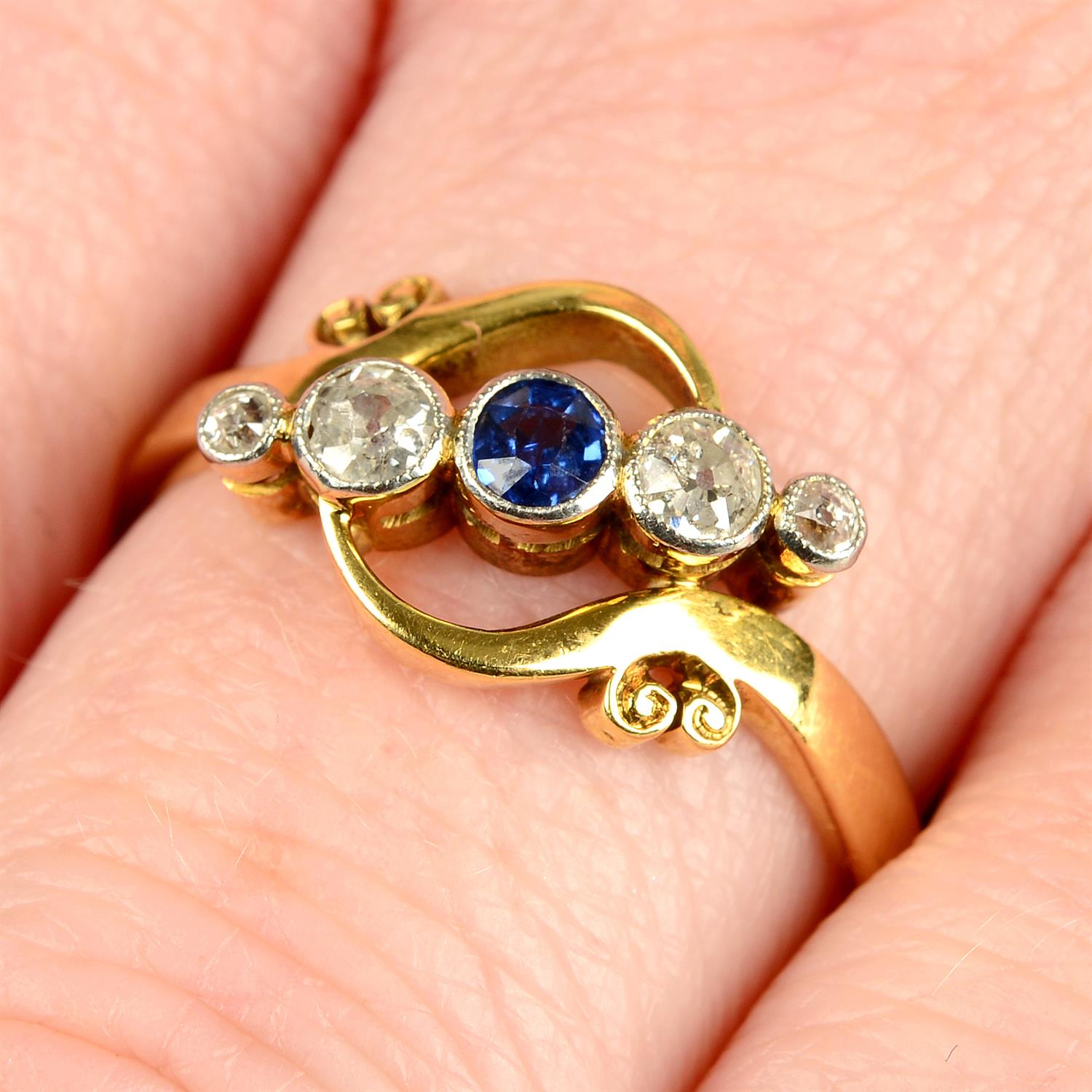 An early 20th century 18ct gold and platinum sapphire and old-cut diamond five-stone crossover ring.