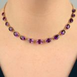 A 19th century gold graduated amethyst rivière necklace, with chain-link back-chain.