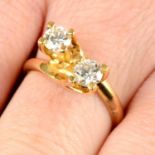 A brilliant-cut diamond two-stone crossover ring.