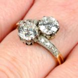 An early 20th century platinum and 18ct gold old-cut diamond two-stone crossover ring.