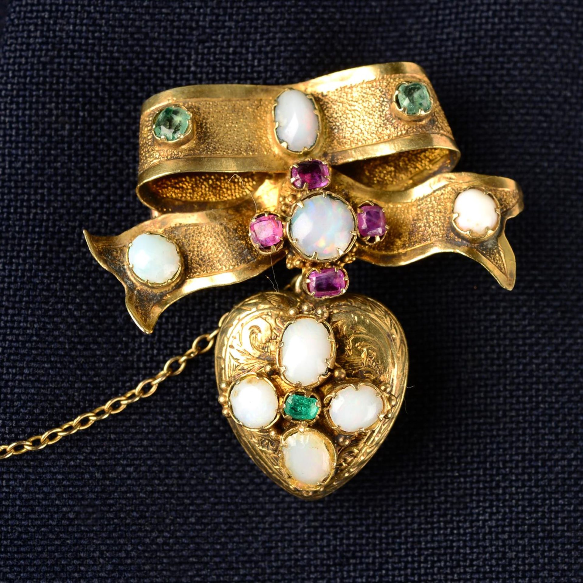 A mid 19th century gold opal, emerald and ruby bow brooch, suspending a similarly-set heart locket.