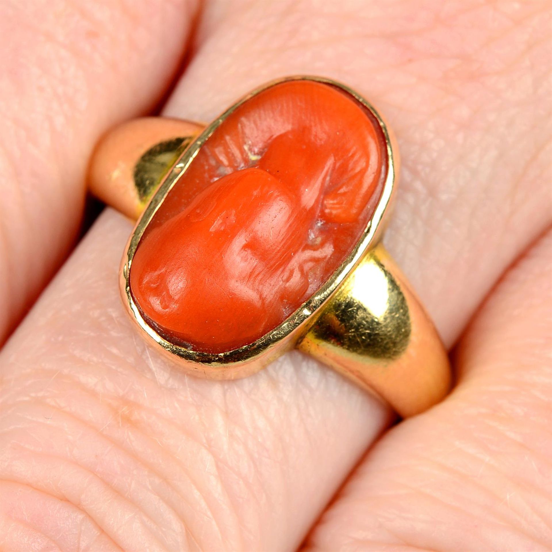 An early 20th century gold coral cameo ring.