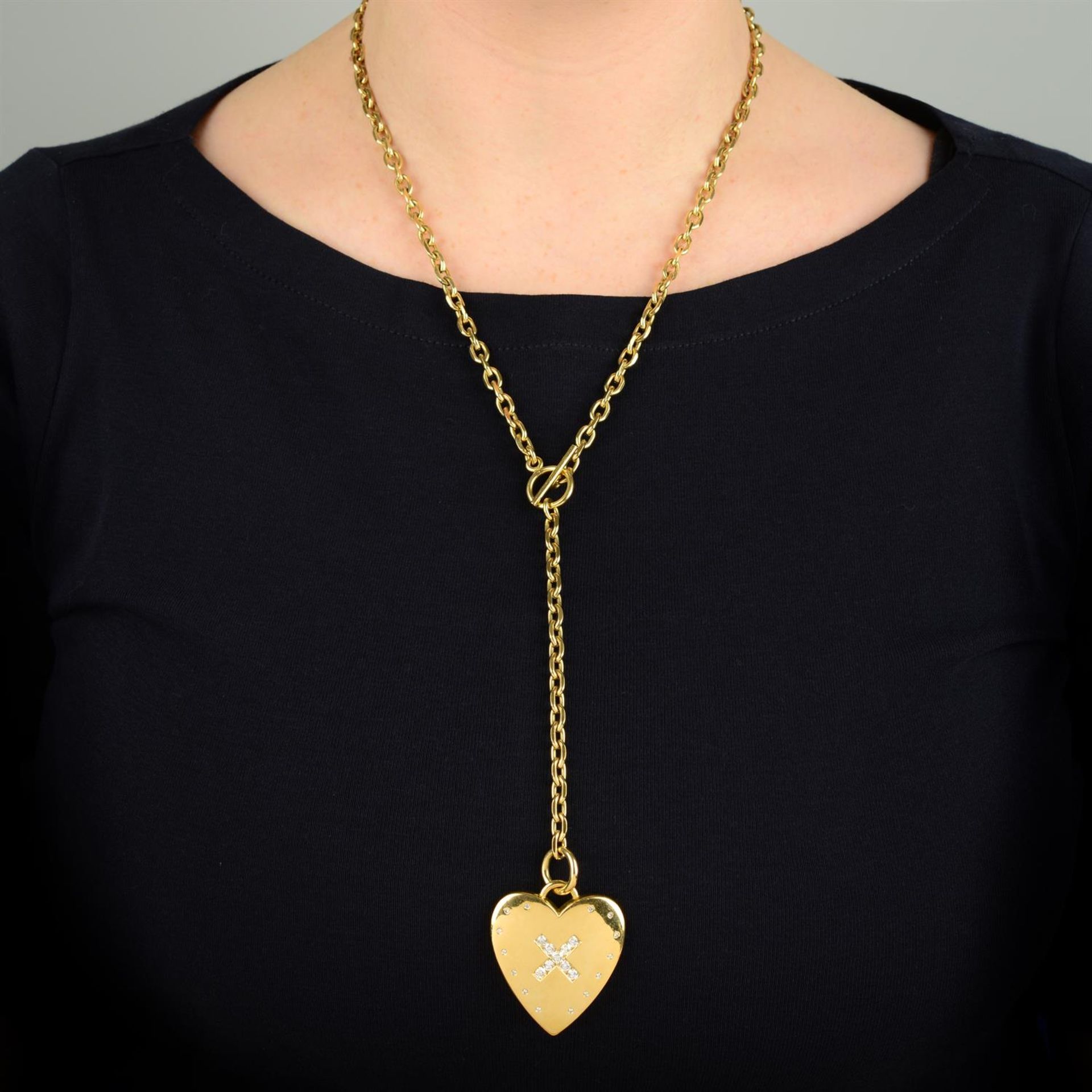 An 18ct gold crossed brilliant-cut diamond heart pendant, on chain.