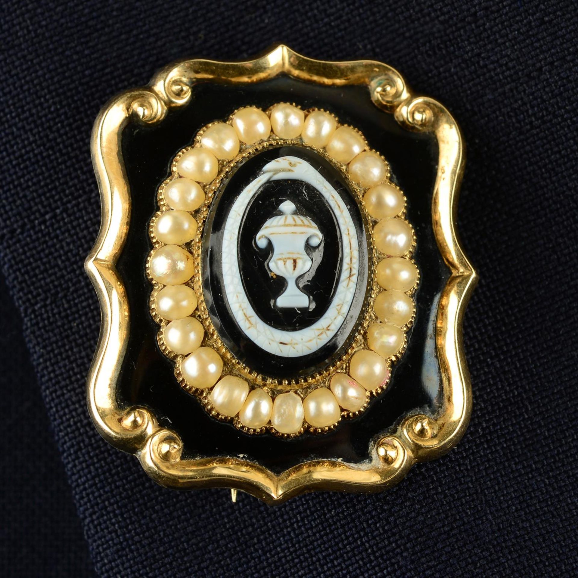 An early Victorian gold carved onyx urn and ouroboros mourning brooch, with split pearl and black