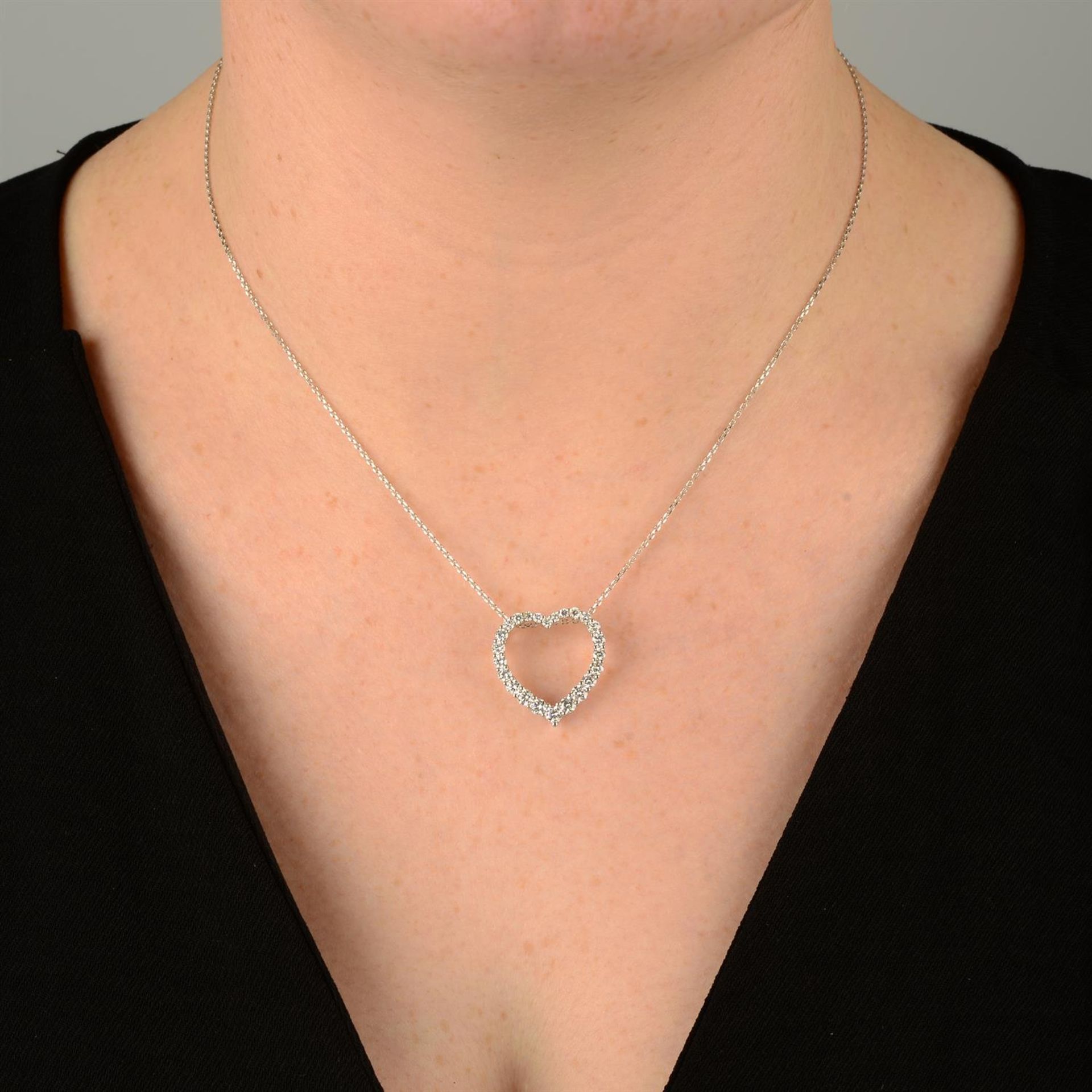 A graduated brilliant-cut diamond heart-shape pendant, with trace-link chain. - Image 5 of 5