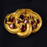 A 19th century gold 'Etruscan Revival' brooch, with garnet foliate highlights.