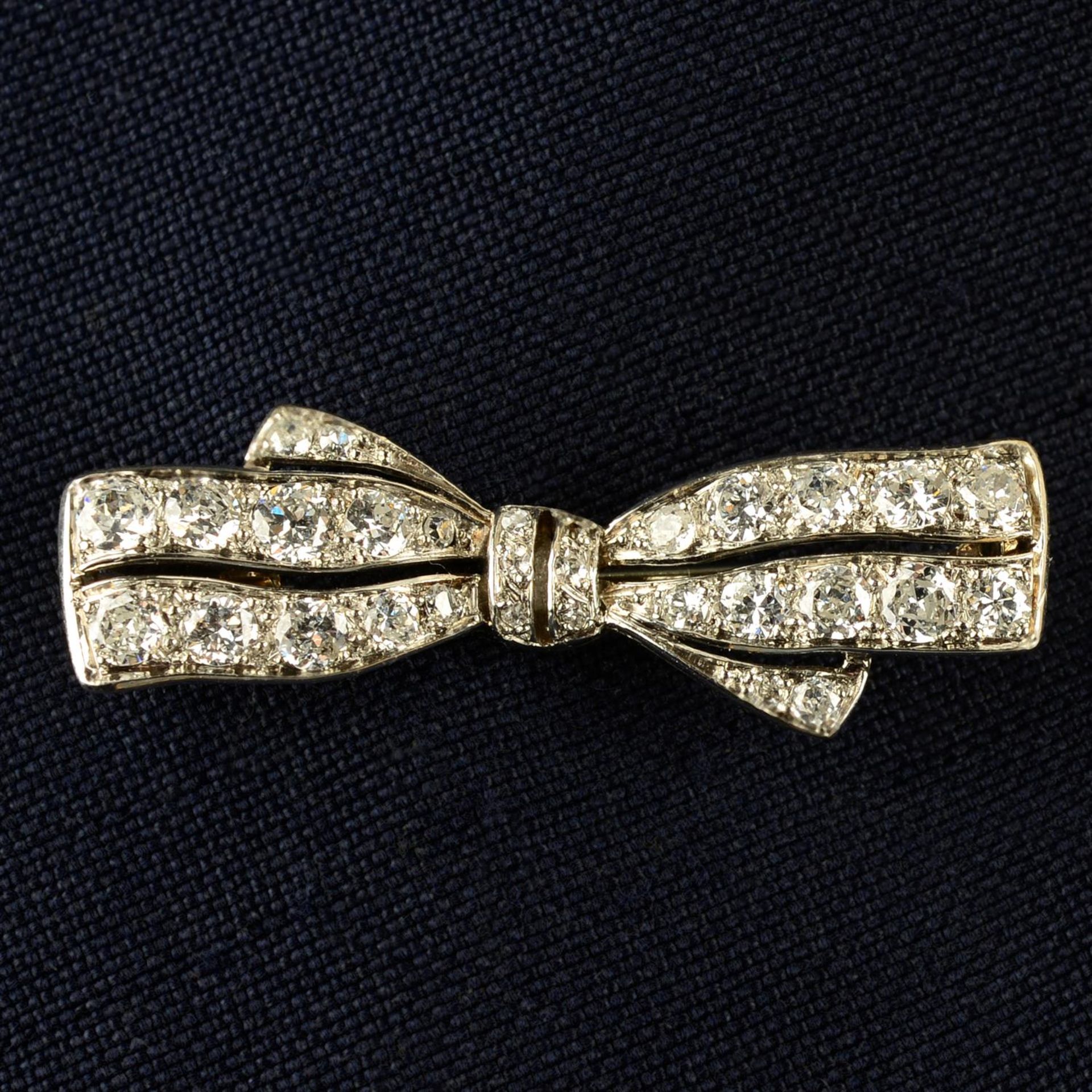 An early 20th century platinum and gold circular-cut diamond bow brooch.