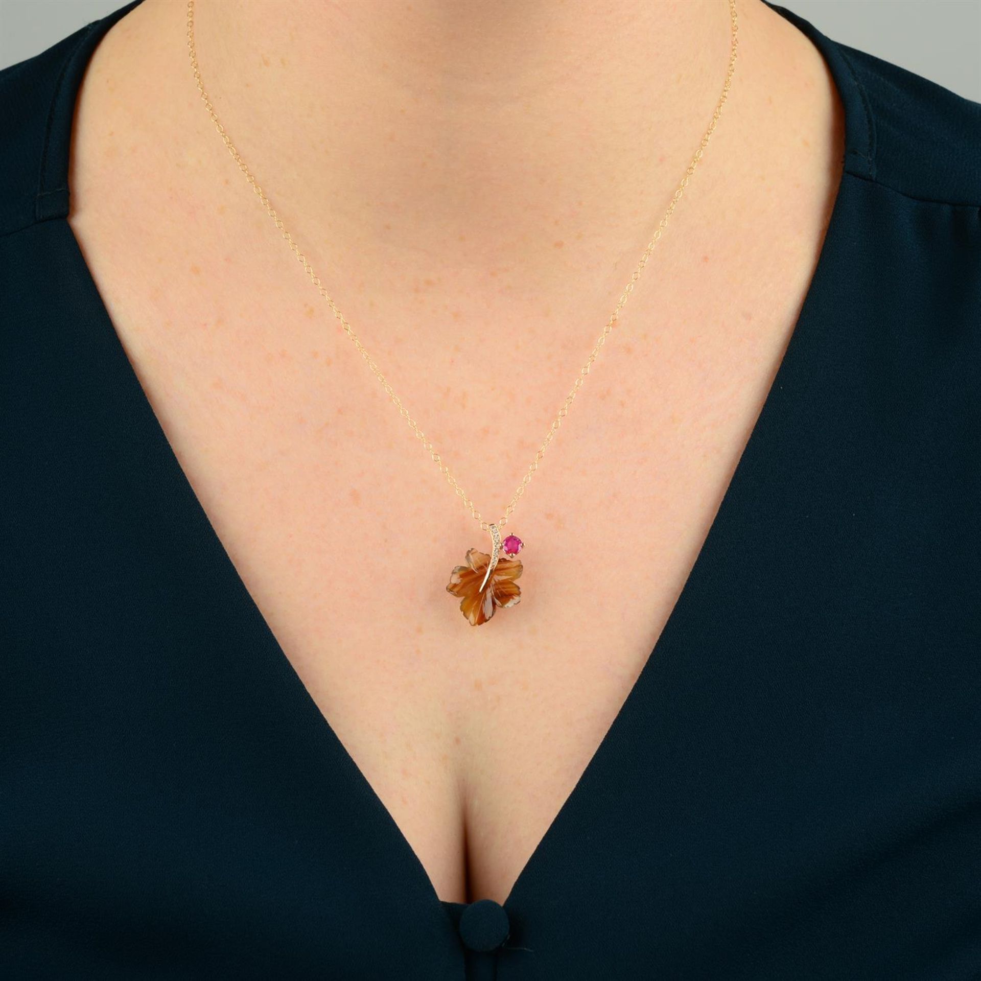 A carved foliate agate pendant, with diamond stem and ruby bud, with chain. - Image 5 of 5