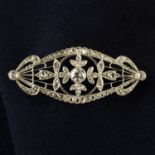 An early 20th century platinum circular-cut and diamond point floral lattice brooch.