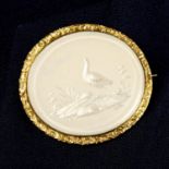 A late 19th century carved mother-of-pearl panel brooch, depicting a bird and flora.