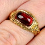 An early to mid 19th century floral embossed 15ct gold garnet cabochon ring.