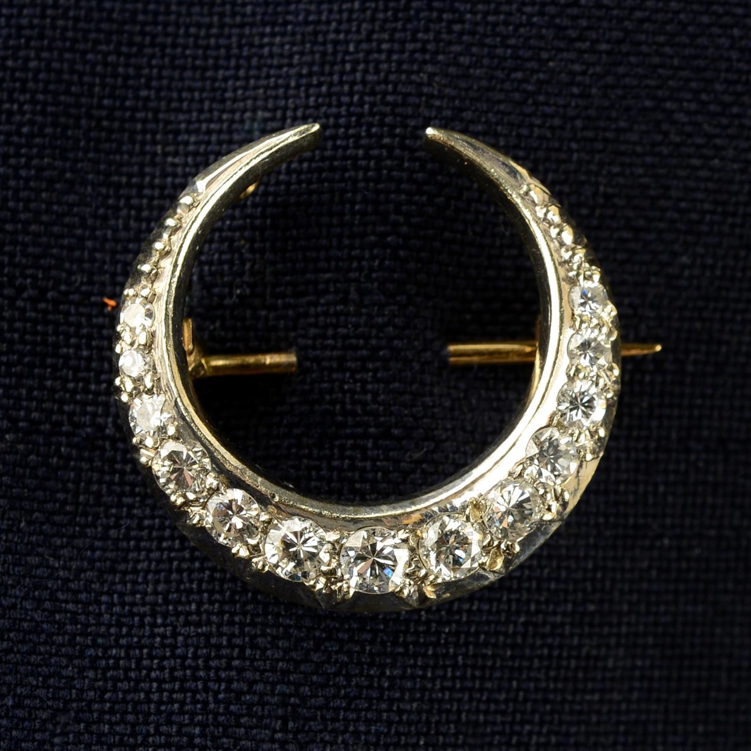 A brilliant and single-cut diamond crescent moon brooch.