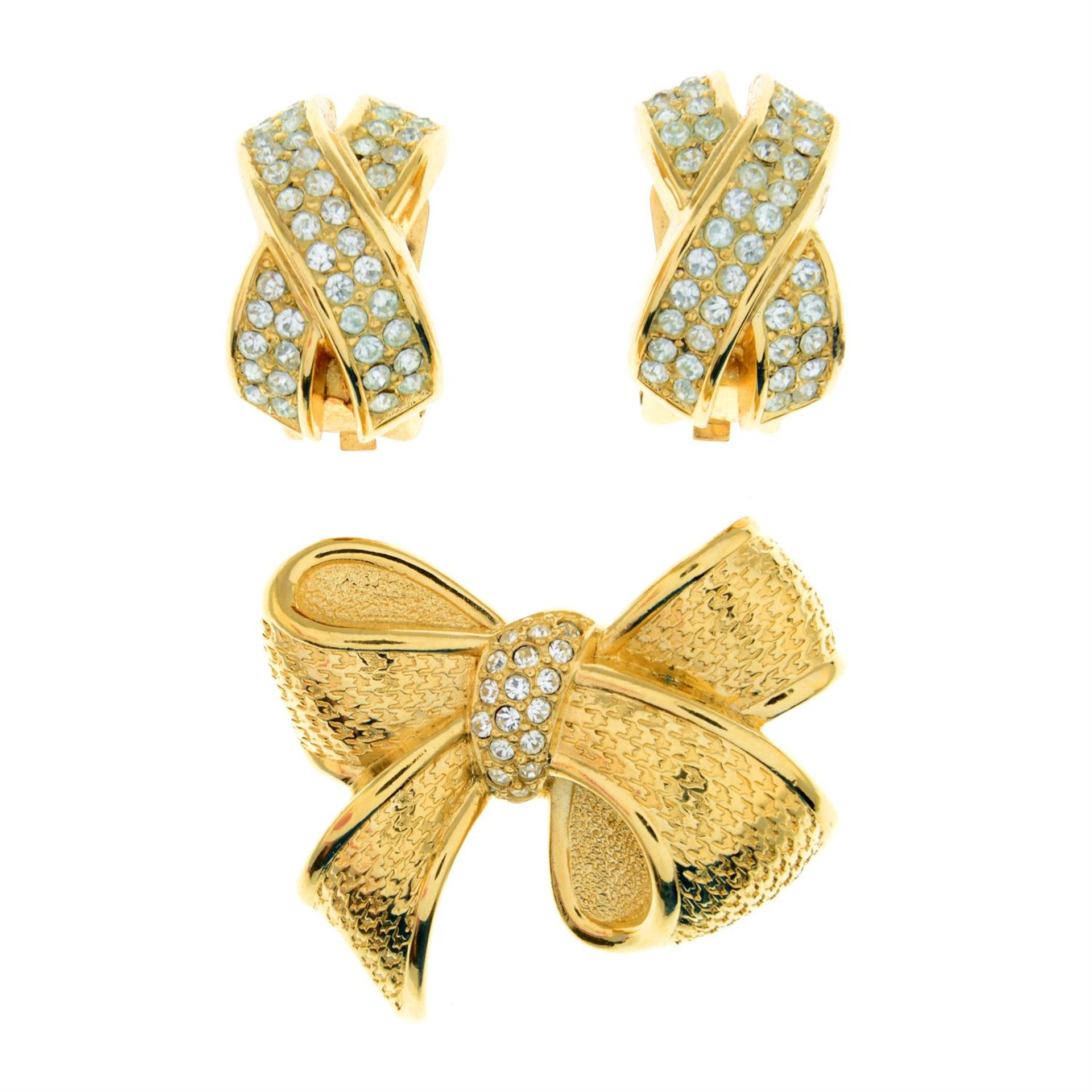 CHRISTIAN DIOR - a textured metal ribbon brooch, together with a pair of clear paste set clip-on