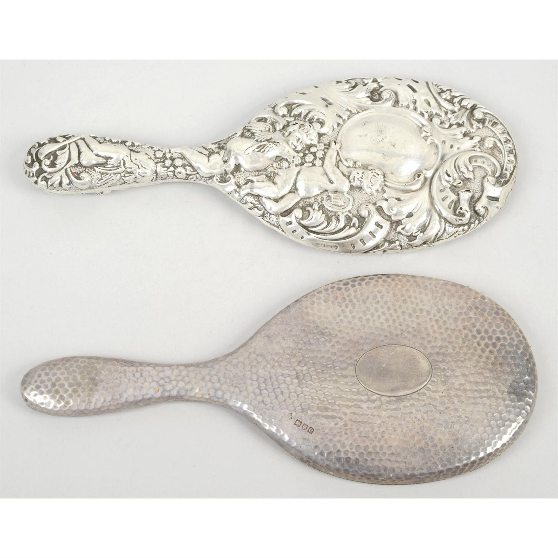 Two late Victorian silver mounted hand-held mirrors; together with a further mirror with plated