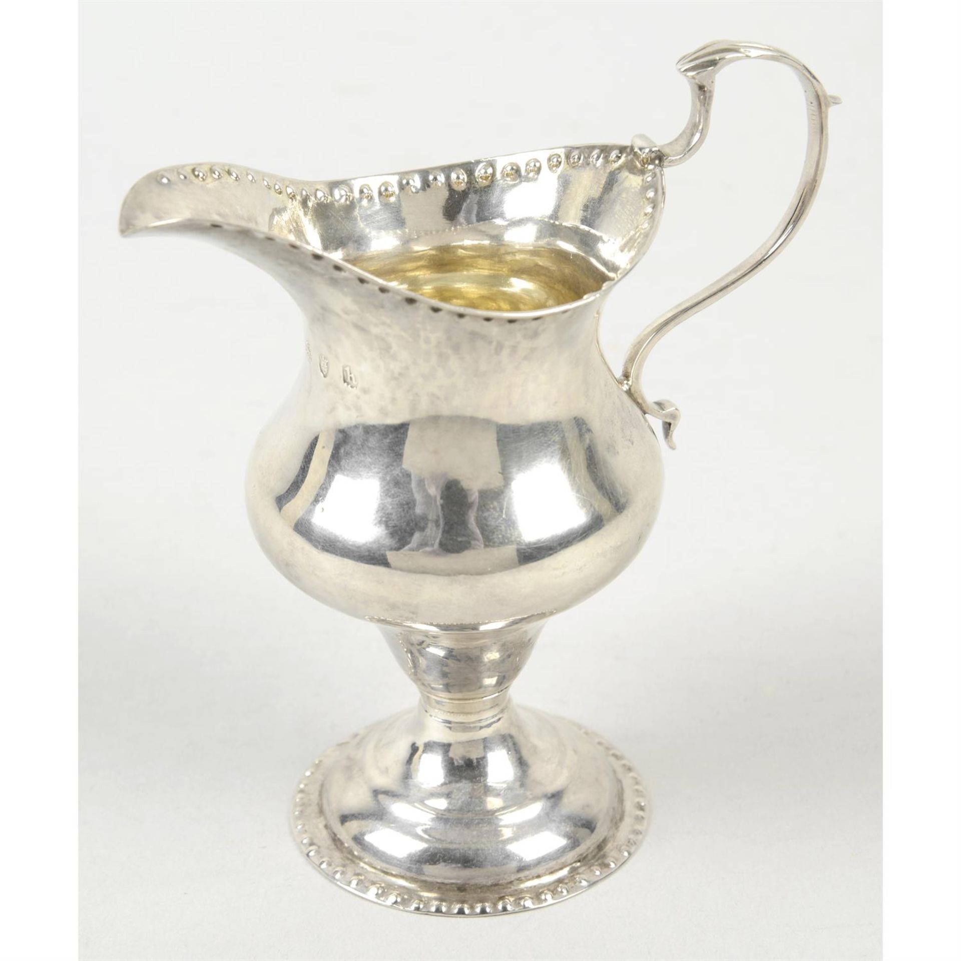 A George III silver pear shape cream jug on spread foot.