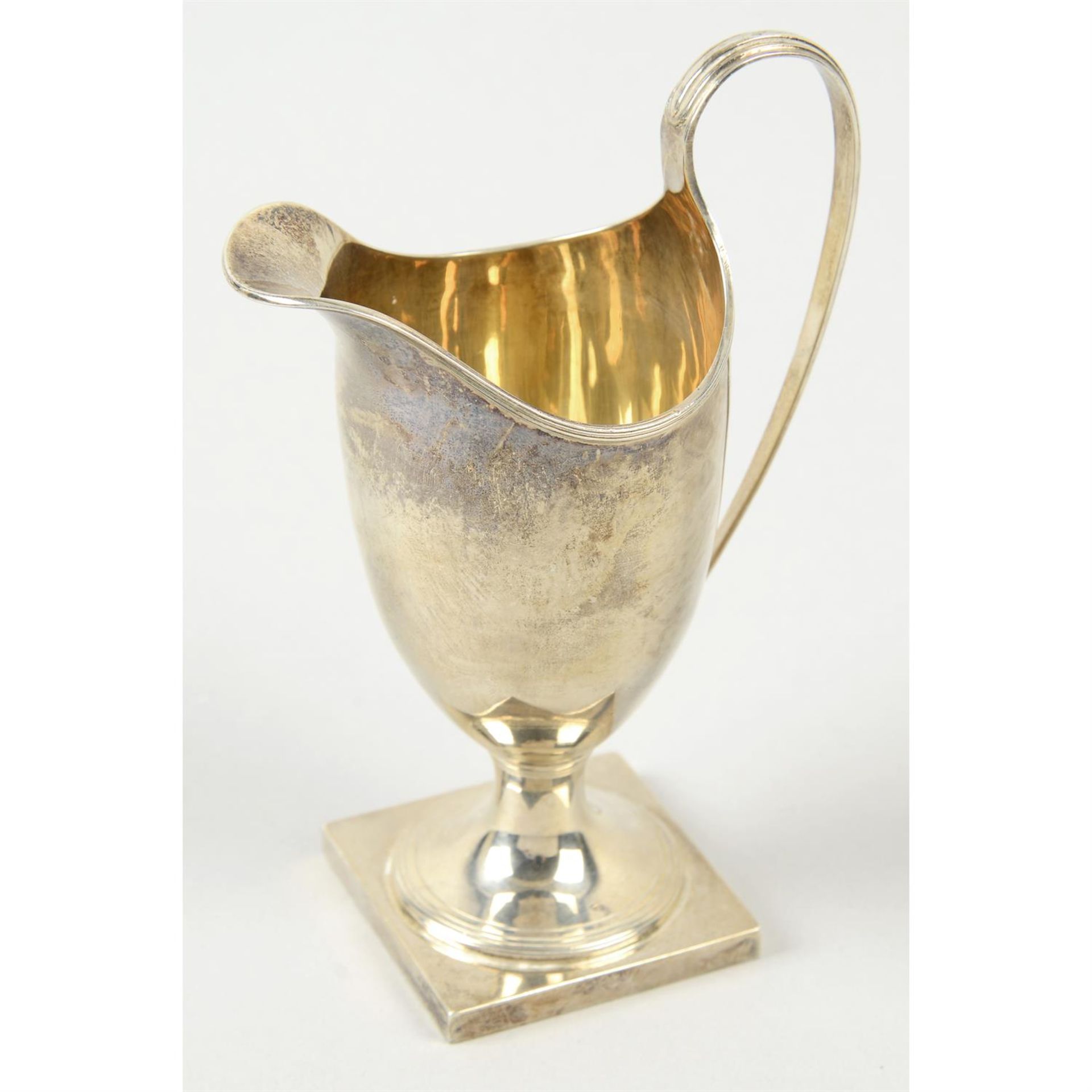 A modern silver helmet shape cream jug.