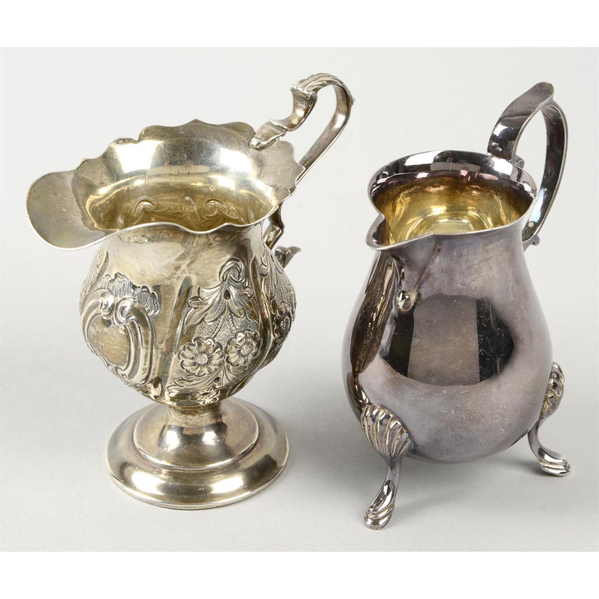 An Edwardian silver pedestal cream jug; together with a later sparrow beak jug. (2).