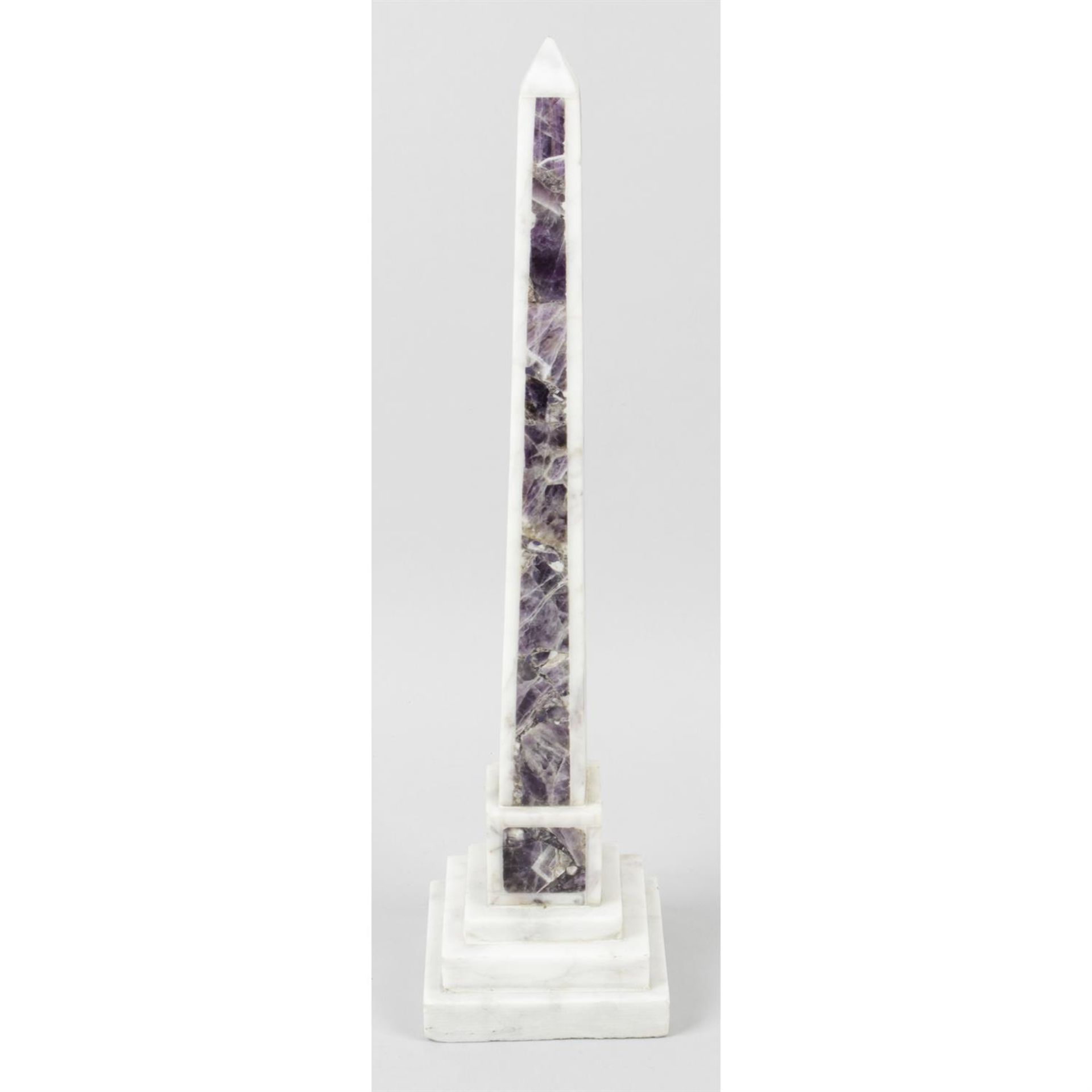 A large white marble and amethyst panelled obelisk.