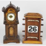An early 20th century stained wooden cased novelty clock, together with a similar desk calendar.