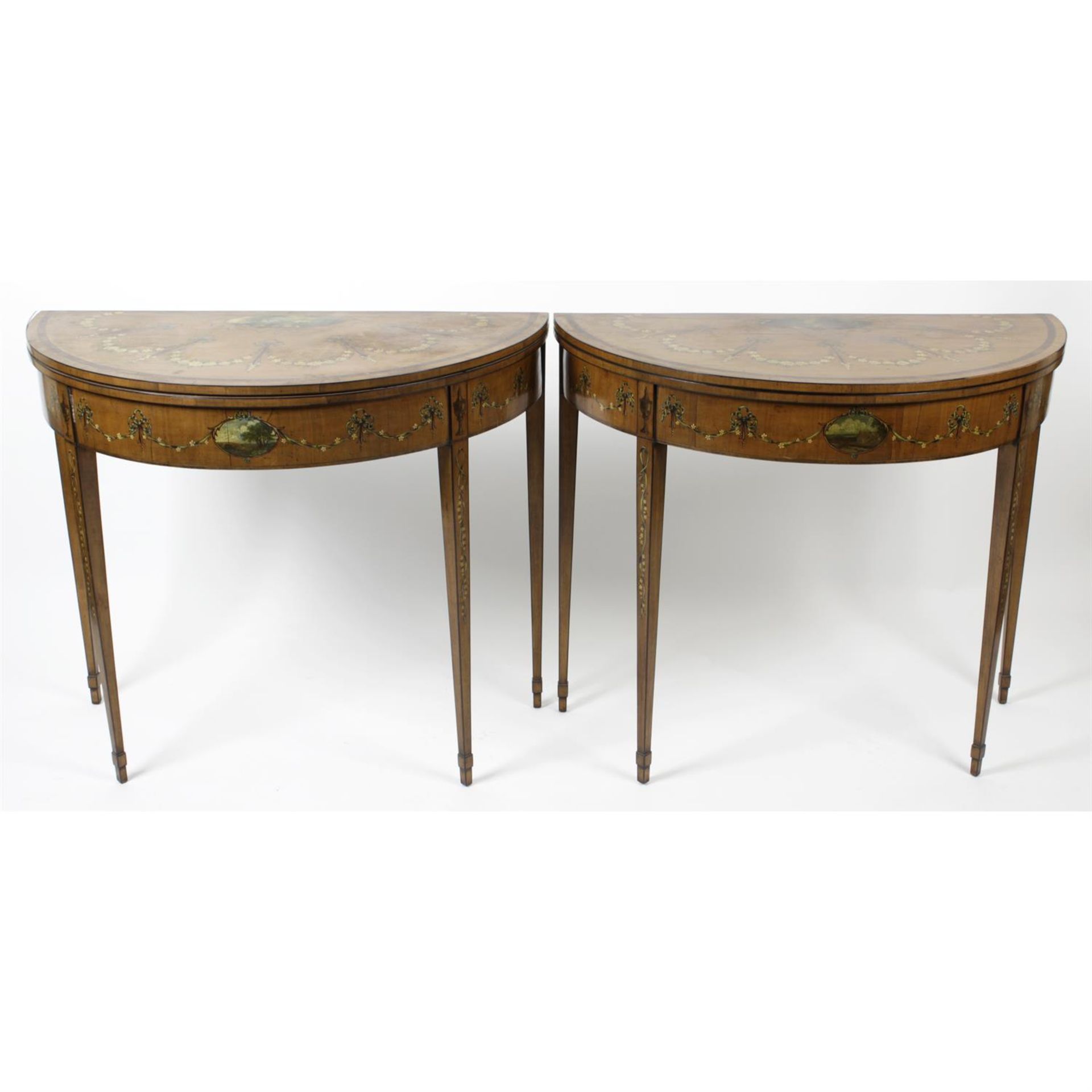 A near pair of early 20th century painted satinwood card tables, each of demi-lune shaped form.