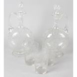 A set of three late 19th/early 20th century clear glass decanters and stoppers, together with with