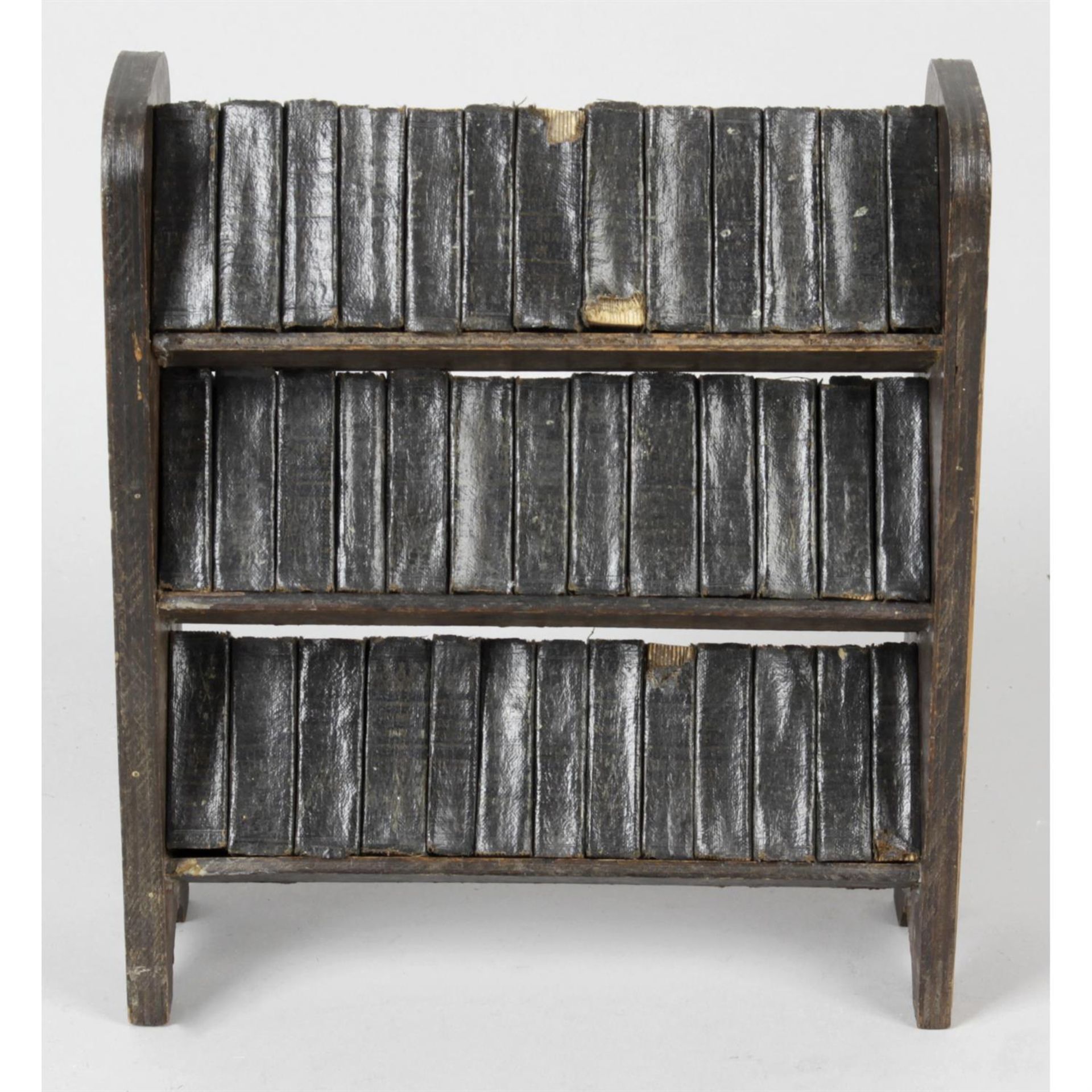 A miniature stained wooden book rack containing 39 miniature books.