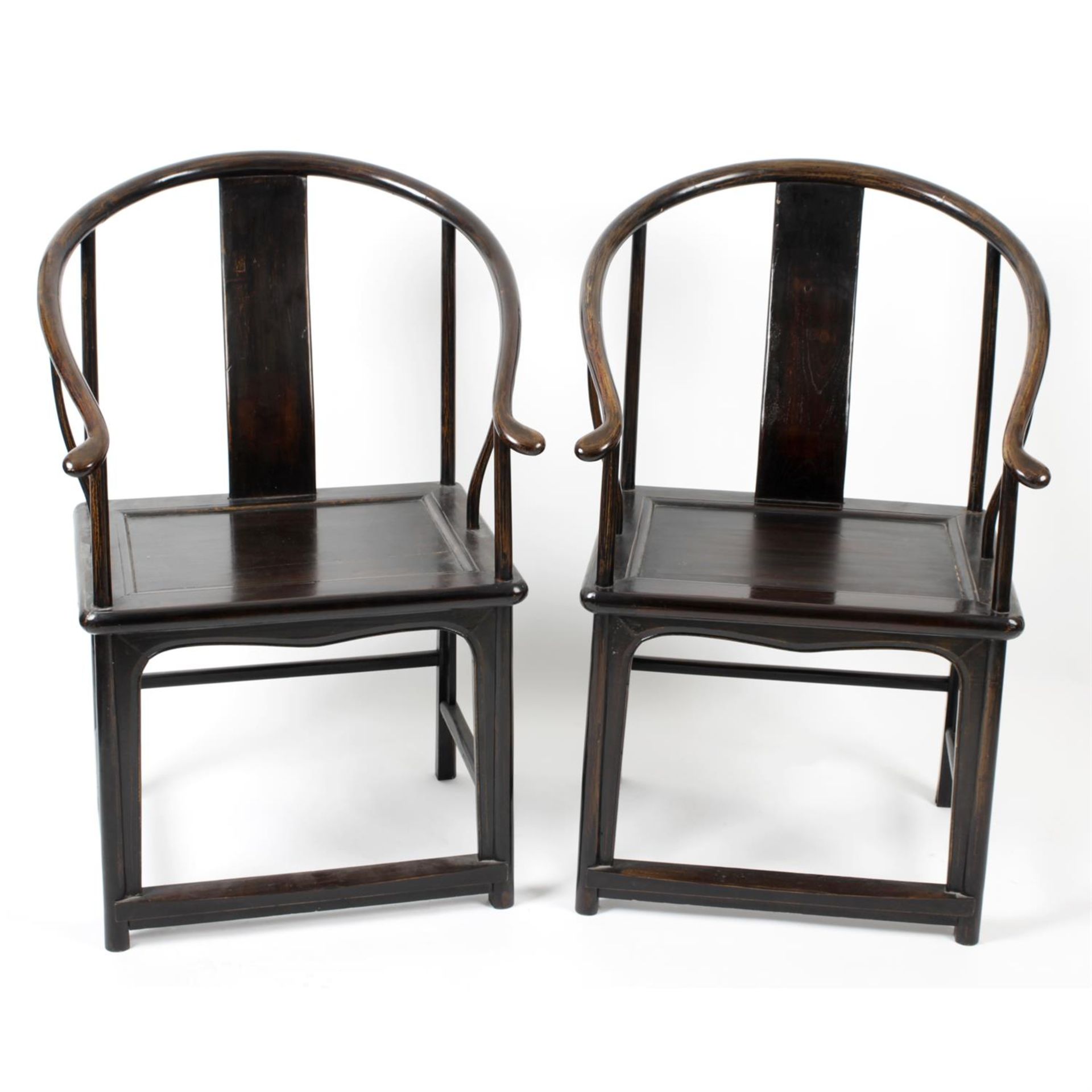 A pair of Chinese stained wooden framed 'horse shoe' chairs.