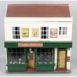 A wooden dolls house modelled as a shop.