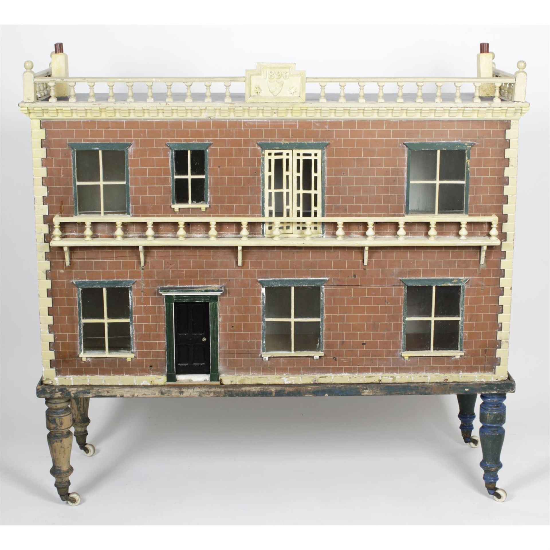 A large late 19th century painted wooden dolls house with miniature furniture and contents.